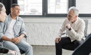 group of men sitting in a room having discussion