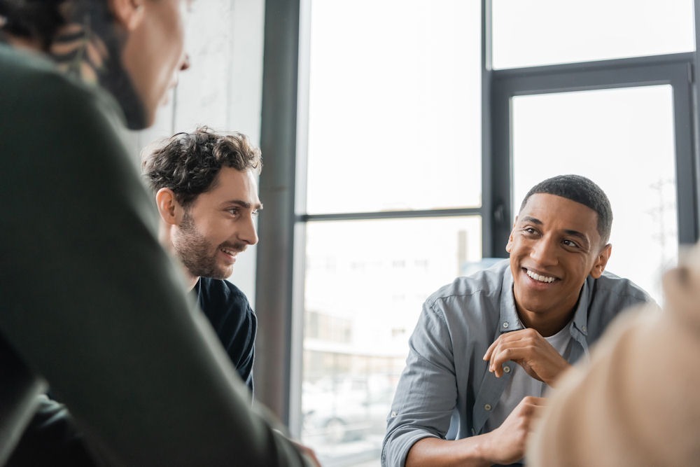 men smiling in a group meeting