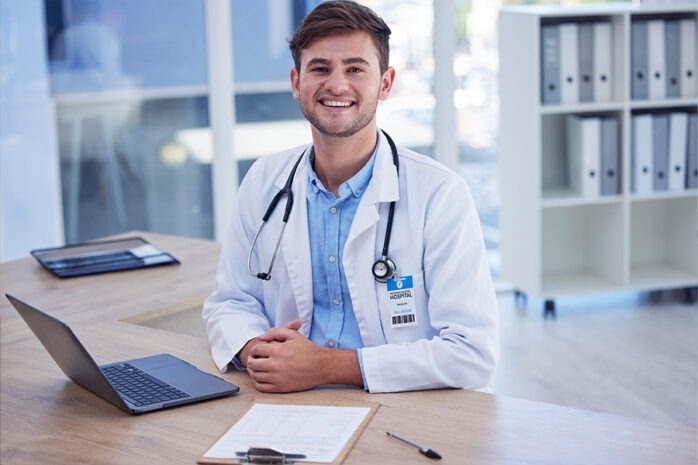 healthcare professional sitting at desk and smiling